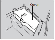 2. Remove the cover and take the jack, stay, wheel nut wrench, and extension