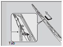 2. Press and hold the tab, then slide the blade from the wiper arm.